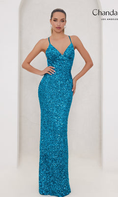 A woman poses in the Long Prom Dress 30045 by Chandalier, a fitted blue sequin gown with thin straps and a v-neckline, its floor-length silhouette shimmering against a plain light background.