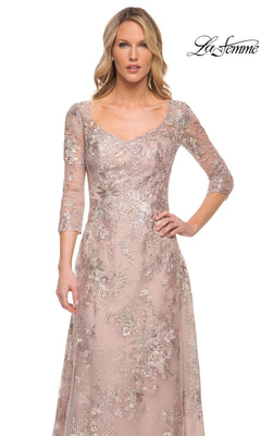 A woman wears a mauve metallic La Femme 30054 formal dress featuring a scoop-neck, three-quarter sleeves, and intricate floral embroidery with sequins.