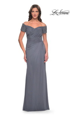 A woman wears the Long Formal Dress: La Femme 30057 in gunmetal, featuring off-the-shoulder beaded short sleeves and a floor-length skirt, standing against a white background.