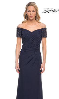 Woman wearing the Long Formal Dress: La Femme 30057, a navy blue off-the-shoulder gown with beaded short sleeves, against a plain white background.