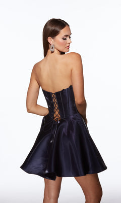 Woman wearing the Lace-Up Strapless Short Hoco Dress: Alyce 30058 with a lace-up corset back, looking over her shoulder against a plain white background.