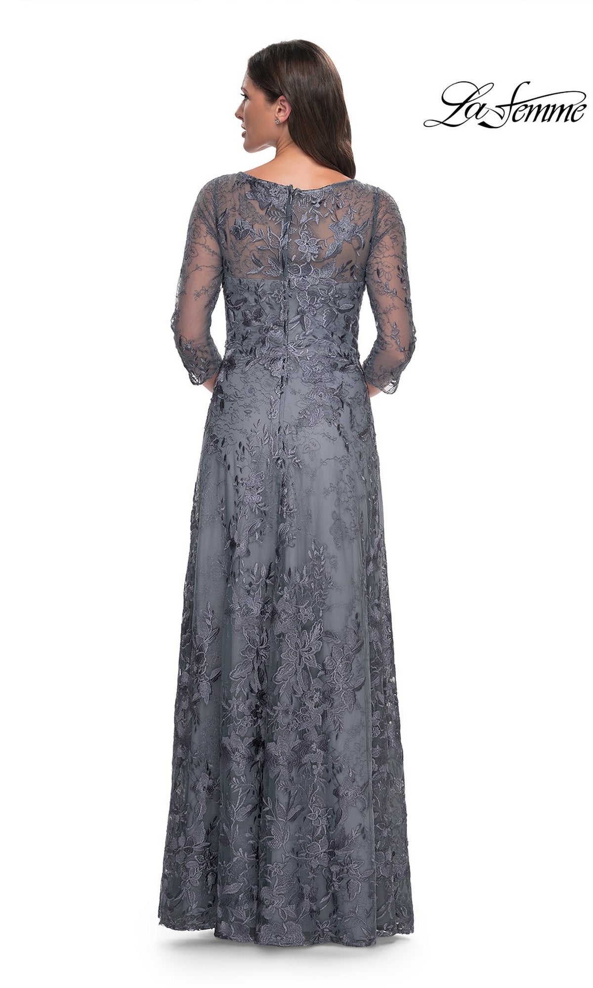 A woman wears the slate grey, floor-length Long Formal Dress: La Femme 30060, featuring three-quarter sleeves and a delicate floral lace overlay.