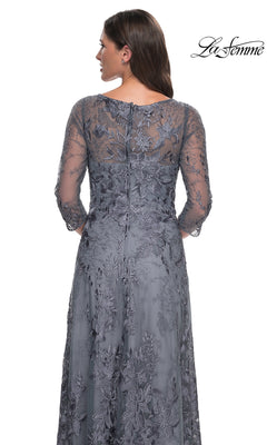 Back view of a woman in a La Femme 30060 floor-length slate grey lace formal dress with three-quarter sleeves and floral embroidery.