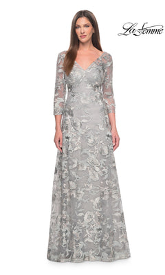 A woman wearing a Long Formal Dress: La Femme 30062 in slate-gray, featuring three-quarter sleeves, a floor-length A-line silhouette, and all-over floral embroidery.