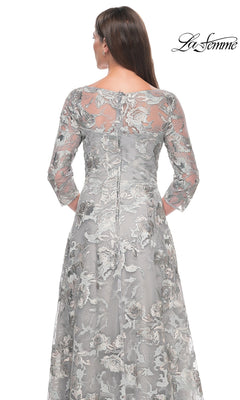 Back view of a grey, three-quarter sleeve La Femme 30062 formal dress featuring an all-over floral lace overlay and a knee-length A-line skirt.