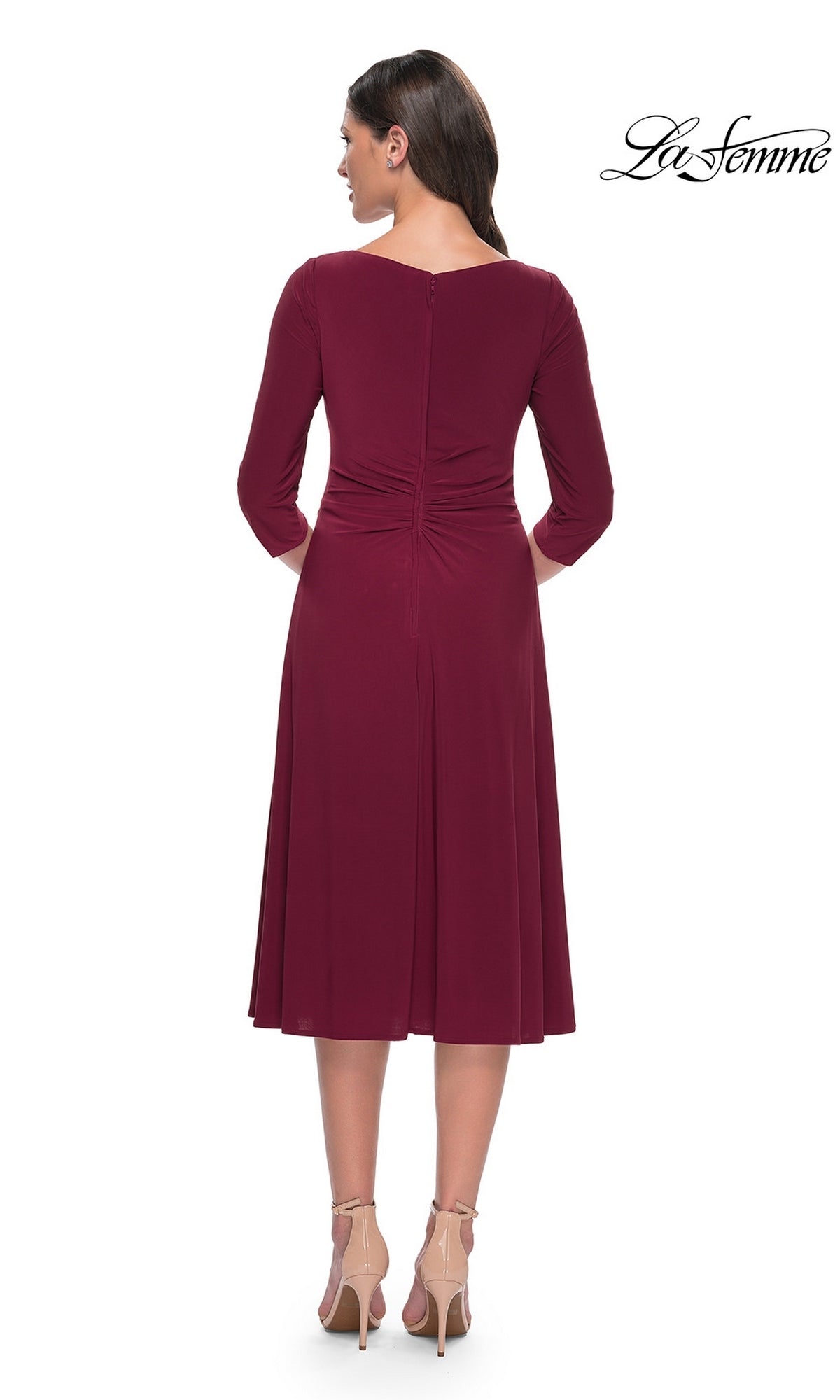Back view of the burgundy Midi Wedding Guest Dress: La Femme 30069, featuring three-quarter sleeves, ruched detailing at the lower back, and worn with nude high heels.