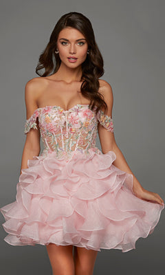A woman wearing the Alyce 30087 short homecoming dress in Rosewater, featuring a fit-and-flare silhouette with a floral embroidered bodice embellished with delicate beaded floral appliques and a layered ruffled skirt, stands against a gray background.