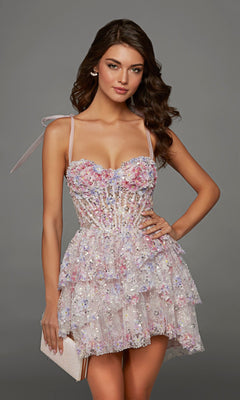 A woman wearing the Short Homecoming Dress: Alyce 30093 in pink, featuring a sleeveless sequin corset bodice and a tiered ruffle skirt, holds a clutch while standing against a plain gray background.