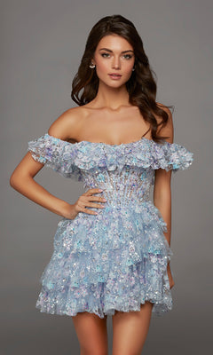 A woman wearing the Alyce 30115 short homecoming dress—an off-the-shoulder, ruffled design in shades of blue and purple with sequin embellishments—posing against a plain gray background.
