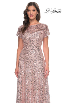 A woman wearing a La Femme 30122 long formal dress featuring a rose gold sequin finish, short sleeves, a jewel neckline, and a floor-length A-line silhouette.