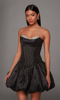 A woman poses against a plain gray background wearing the Short Homecoming Dress: Alyce 30125 in Black/Silver, featuring a strapless, rhinestone-embellished corset-style bodice and a bubble hem A-line skirt.