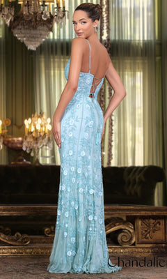 A woman stands in an elegant room wearing the Long Prom Dress 30157 by Chandalier, a light blue, floor-length floral beaded gown with spaghetti straps and an open back.