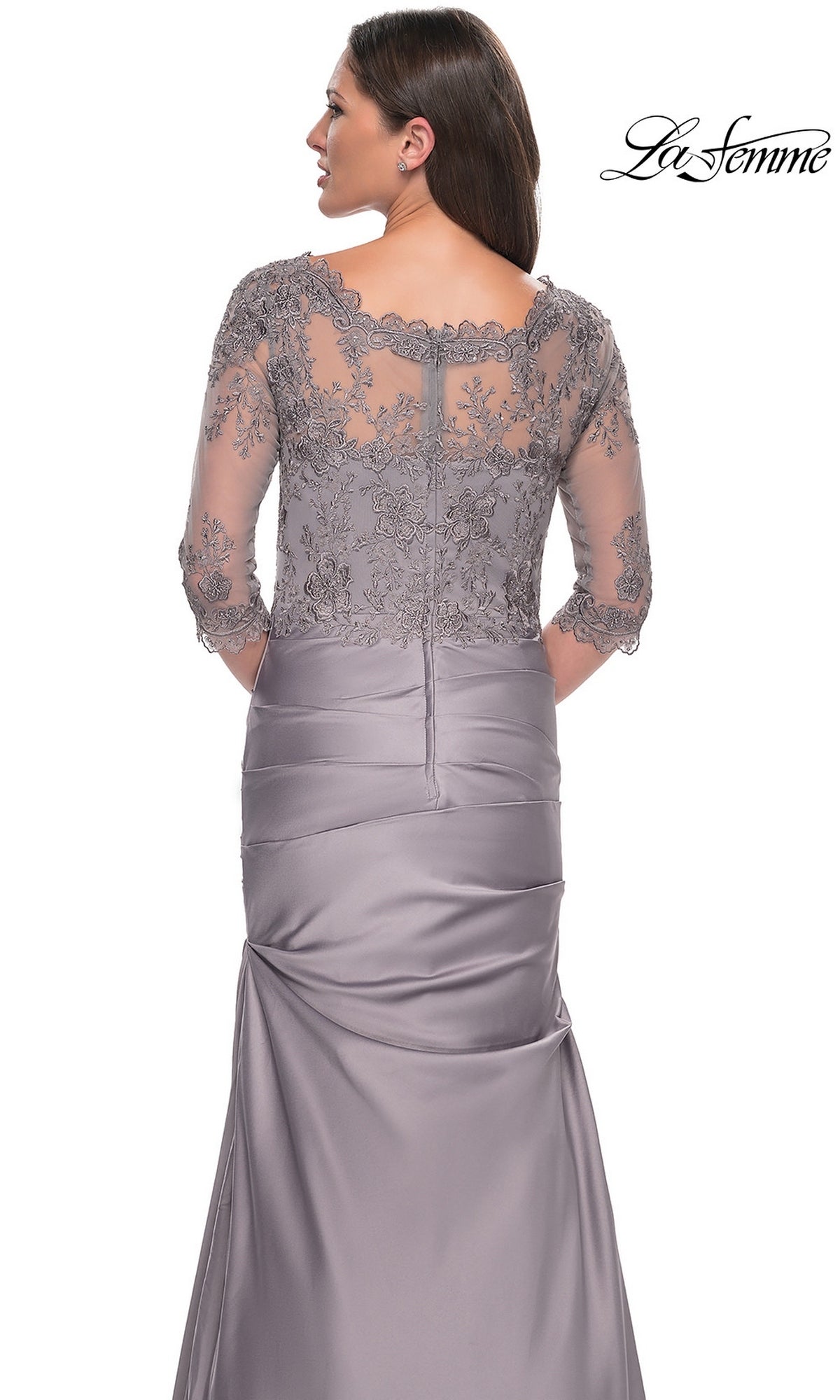 A woman models the Long Formal Dress: La Femme 30162, featuring a silver-gray lace bodice and sheer floral-embroidered back and sleeves, shown from behind.