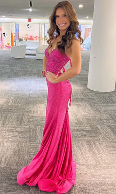 A woman smiles indoors on gray carpet, wearing the fitted, floor-length Open-Back Sparkly Long Beaded Prom Dress 3018 in bright pink, featuring thin straps and side cutouts.