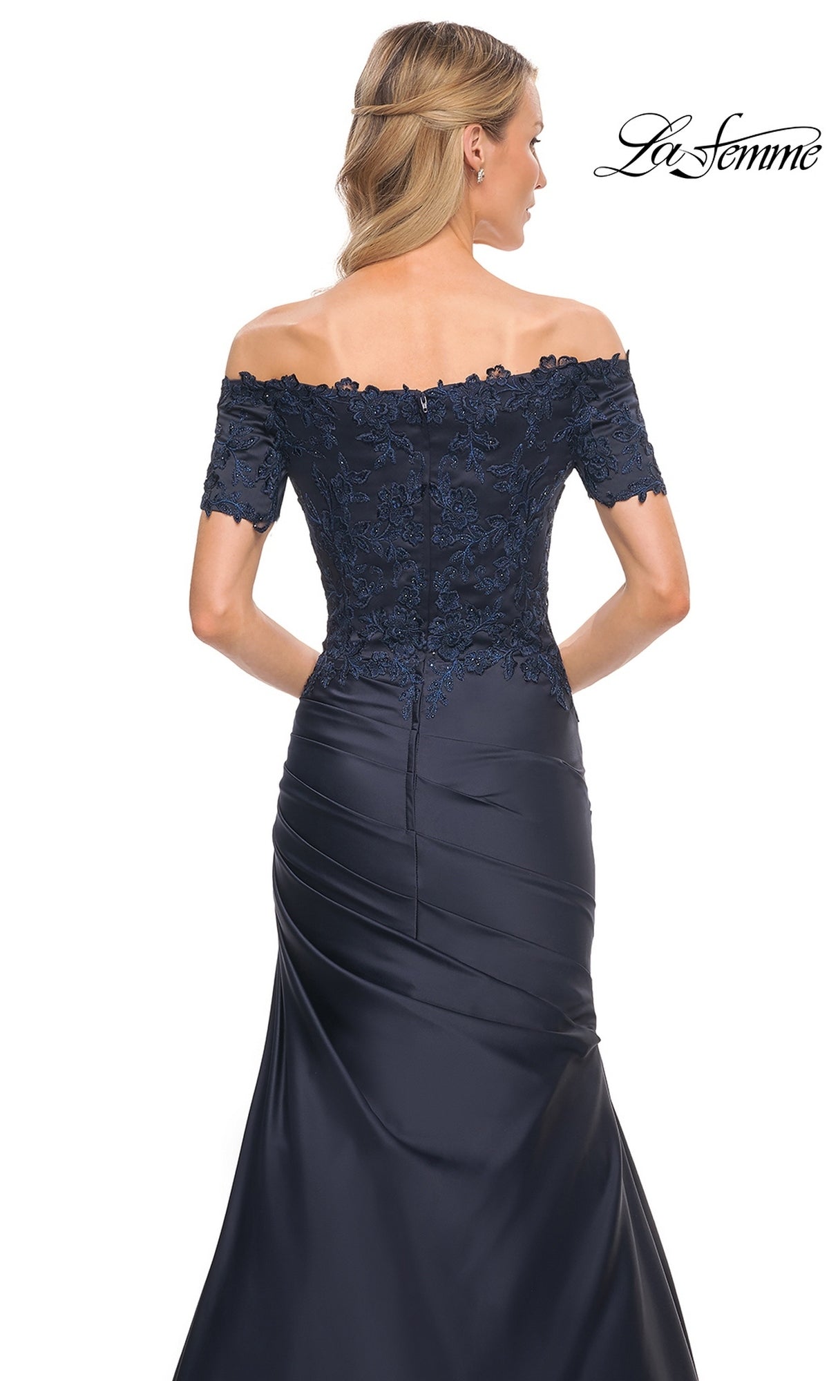 Back view of a navy lace bodice mermaid silhouette La Femme 30199 gown featuring an off-the-shoulder neckline and a floor-length satin skirt with side ruching.