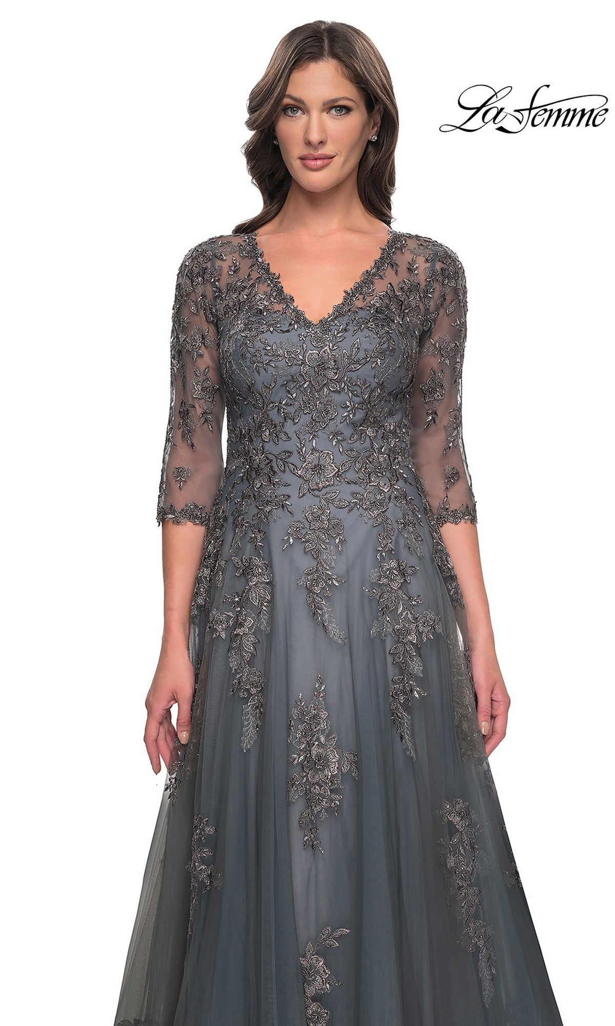 A woman wearing a charcoal gray, V-neck La Femme 30201 mother of the bride dress with three-quarter sleeves and floral lace appliques.