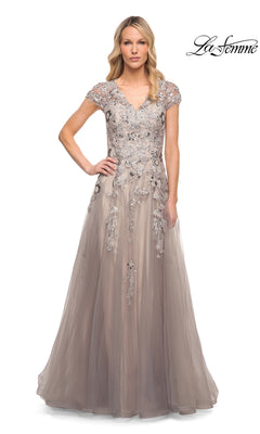 A woman wears the Long Formal Dress: La Femme 30239, a silver and pink tulle gown with cap sleeves and silver floral embroidery on the bodice and skirt.