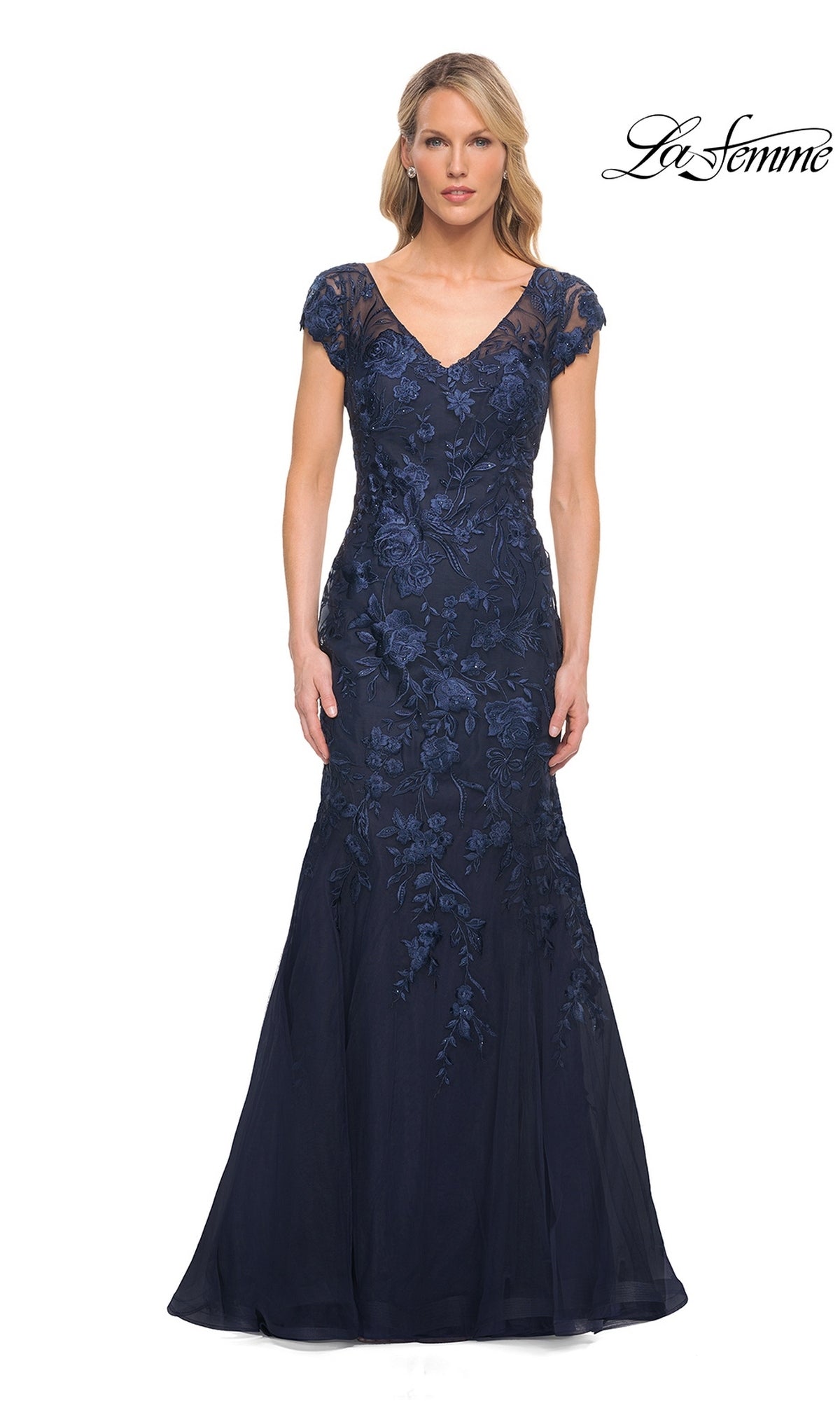 Woman wearing a navy, floor-length, short-sleeved V-neck La Femme 30269 formal dress with a mermaid silhouette and floral lace embroidery.