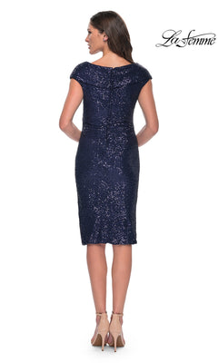 Woman wearing the Knee Length Wedding Guest Dress: La Femme 30323 in navy blue sequins, sheath silhouette with cap sleeves, viewed from the back and paired with nude heels.