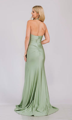 A woman models the V-Neck Long Halter Prom Dress: Amelia Couture 3040, standing with her back to the camera to showcase the ruched detailing and floor-length design against a plain background.