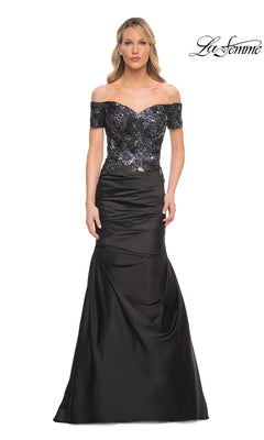 A woman wearing a black Long Formal Dress: La Femme 30404, featuring an off-the-shoulder mermaid silhouette with a sequined bodice and a floor-length skirt.