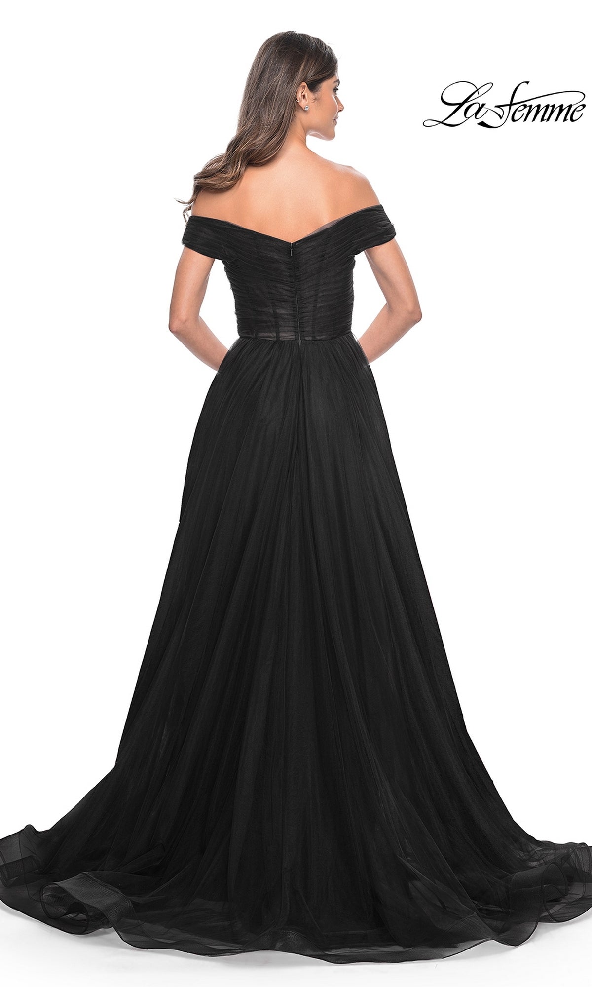 A woman stands facing away in the La Femme Off-Shoulder Long Prom Ball Gown 30498, featuring a striking off-the-shoulder design and flowing skirt; the La Femme logo is visible in the top right corner.