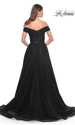 A woman stands facing away in the La Femme Off-Shoulder Long Prom Ball Gown 30498, featuring a striking off-the-shoulder design and flowing skirt; the La Femme logo is visible in the top right corner.