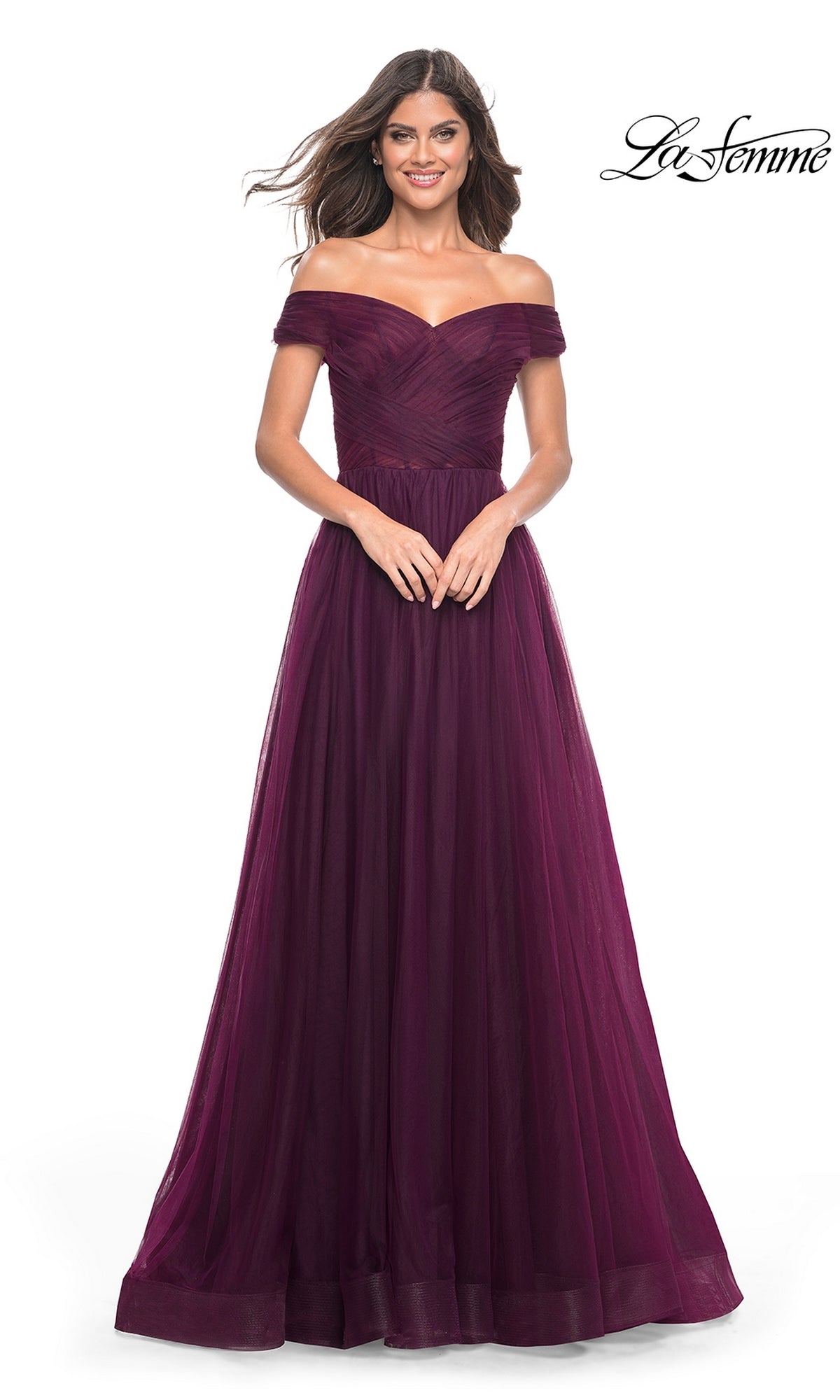 A woman wears the La Femme Off-Shoulder Long Prom Ball Gown 30498—a floor-length, dark purple dress with a fitted bodice and flowing skirt.