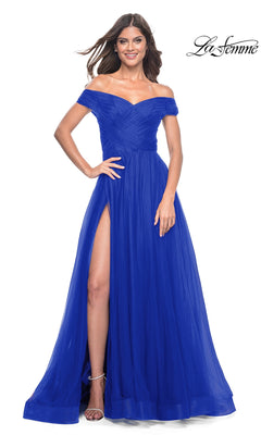 A woman smiles in the La Femme Off-Shoulder Long Prom Ball Gown 30498 in royal blue, featuring a ruched bodice and high slit. The La Femme logo appears in the top right corner.