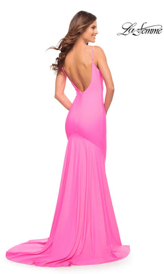 A woman wearing a La Femme 30682 floor-length, hot pink gown with a figure-hugging silhouette, a low, open back, and spaghetti straps.