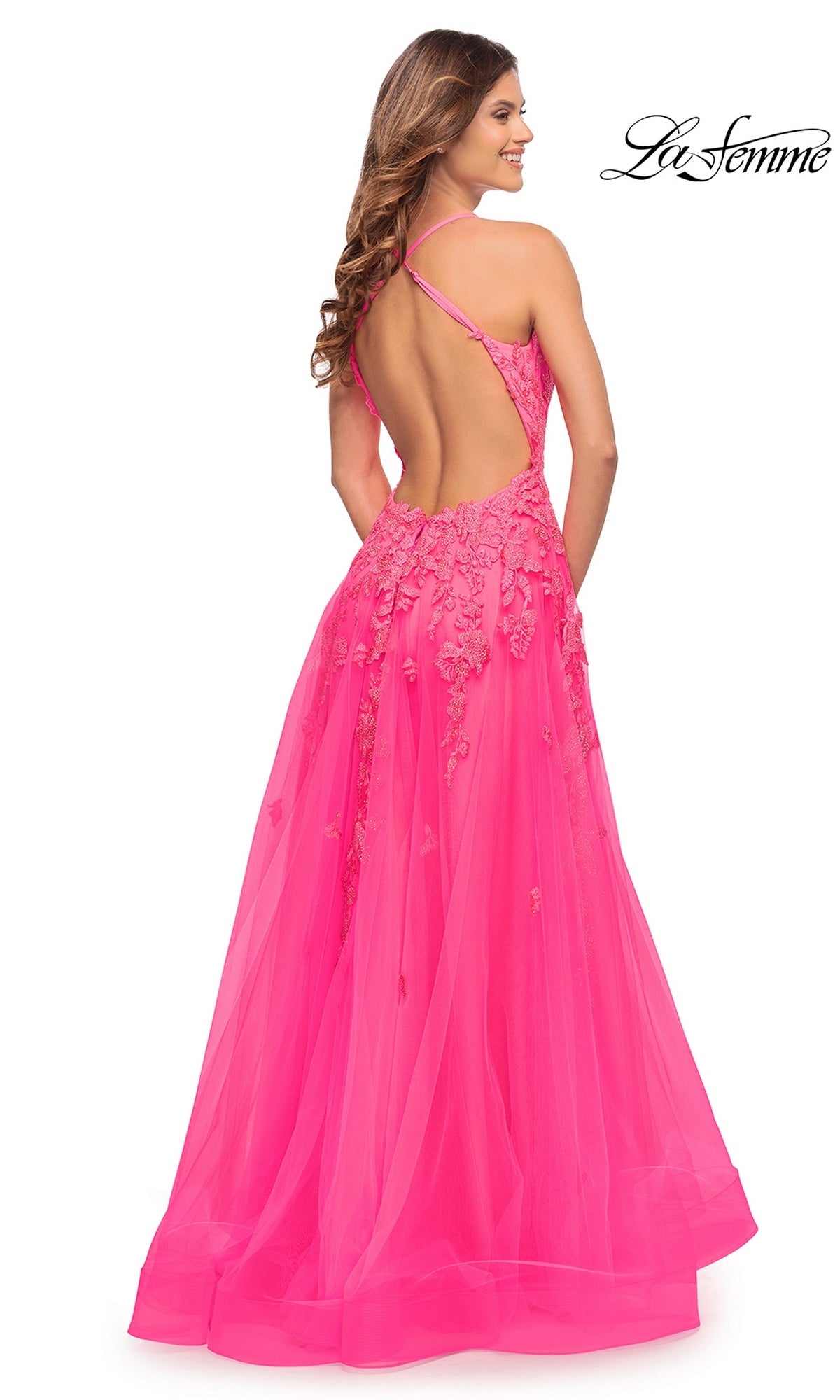 Back view of the neon pink La Femme 30693 prom dress featuring a sleeveless lace bodice, an open back with crisscross straps, and a full tulle skirt.