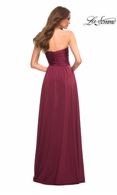 Woman in the Long Prom Dress: La Femme 30700, a strapless burgundy jersey gown with a sweetheart neckline, stands with her back to the camera against a white background.