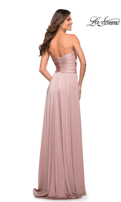 Woman poses with her back to the camera in a blush pink Long Prom Dress: La Femme 30700, featuring a strapless jersey design, ruched bodice, and sweetheart neckline.