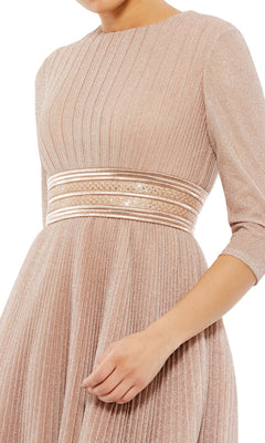 A person is wearing the Mac Duggal 30750 Tea-Length Wedding Guest Dress in light pink with pleats, long sleeves, and a gold-striped waistband—a modest midi party dress. The head is not visible.