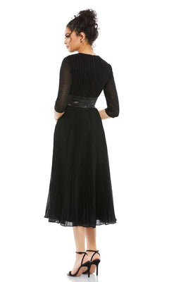 Woman stands with her back to the camera, wearing the Mac Duggal 30750 tea-length wedding guest dress in black with three-quarter sleeves, paired with black high-heeled sandals.