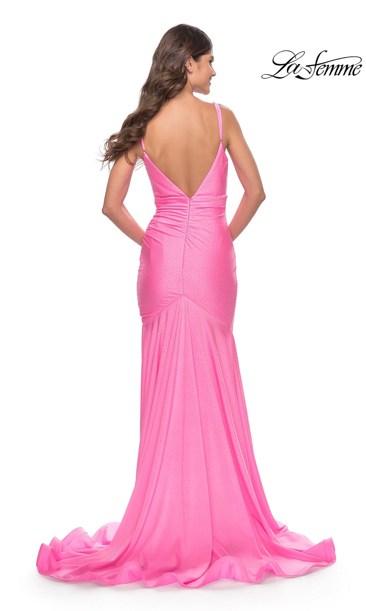 A woman wearing the La Femme Beaded Long Mermaid Prom Dress 30768 in pink, with thin straps, a deep V-back, fitted floor-length silhouette, and a slight train, stands against a white background.