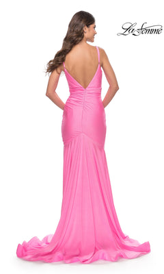 A woman wearing the La Femme Beaded Long Mermaid Prom Dress 30768 in pink, with thin straps, a deep V-back, fitted floor-length silhouette, and a slight train, stands against a white background.