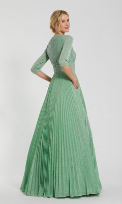 A woman faces away, wearing the Sage Long Pleated Formal Dress by Mac Duggal (30775), featuring three-quarter sleeves and a shimmering pleated A-line silhouette.
