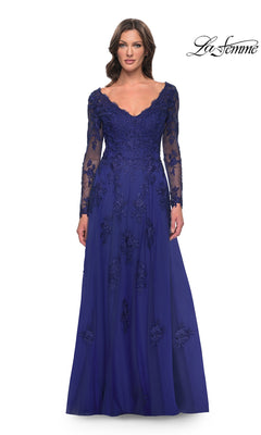 A woman wears a marine blue Long Formal Dress: La Femme 30795, a gown featuring beaded lace appliqués on the V-neck bodice and a tulle A-line skirt.