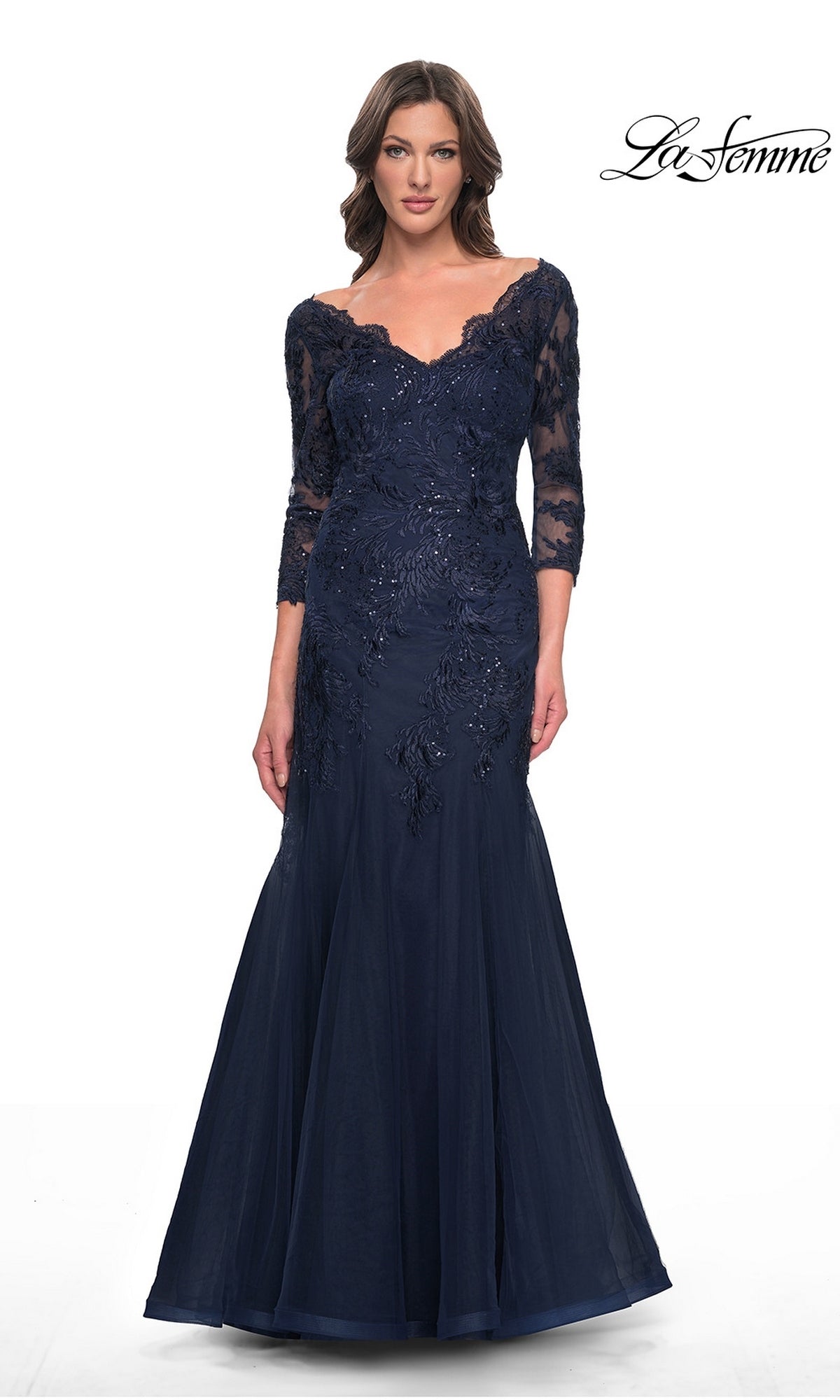 A woman wears a navy La Femme 30823, an off-the-shoulder, floor-length modest lace mermaid dress with three-quarter sleeves and formal embroidery.