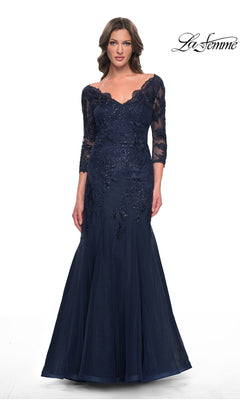 A woman wears a navy La Femme 30823, an off-the-shoulder, floor-length modest lace mermaid dress with three-quarter sleeves and formal embroidery.