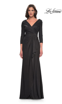 A woman wears a gunmetal La Femme 30845 formal dress featuring a V-neck, ruched bodice, and three-quarter length sleeves.