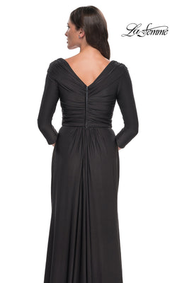 Back view of a woman wearing a floor-length, ruched La Femme 30845 formal dress featuring a V-neckline and three-quarter length sleeves.