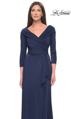 A woman wearing a navy blue Long Formal Dress: La Femme 30845 featuring a V-neck, ruched bodice, and three-quarter length sleeves.
