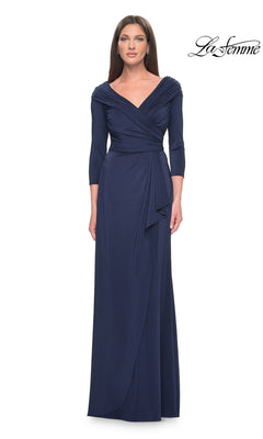 A woman wears a navy, floor-length La Femme 30845 jersey formal gown with a V-neckline, draped bodice, and three-quarter length sleeves.