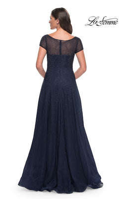 Back view of a woman wearing a floor-length navy blue La Femme 30852 formal dress with short sleeves and a sheer, rhinestone beaded bodice.