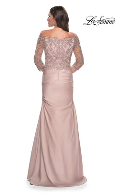 La Femme 30853 is a dusty rose, floor-length off-the-shoulder gown with an embroidered lace bodice, three-quarter length sleeves, and a trumpet skirt.