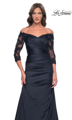 The La Femme 30853 is a dark navy off-the-shoulder formal gown with a ruched bodice, three-quarter length sheer lace sleeves, and a long trumpet skirt.