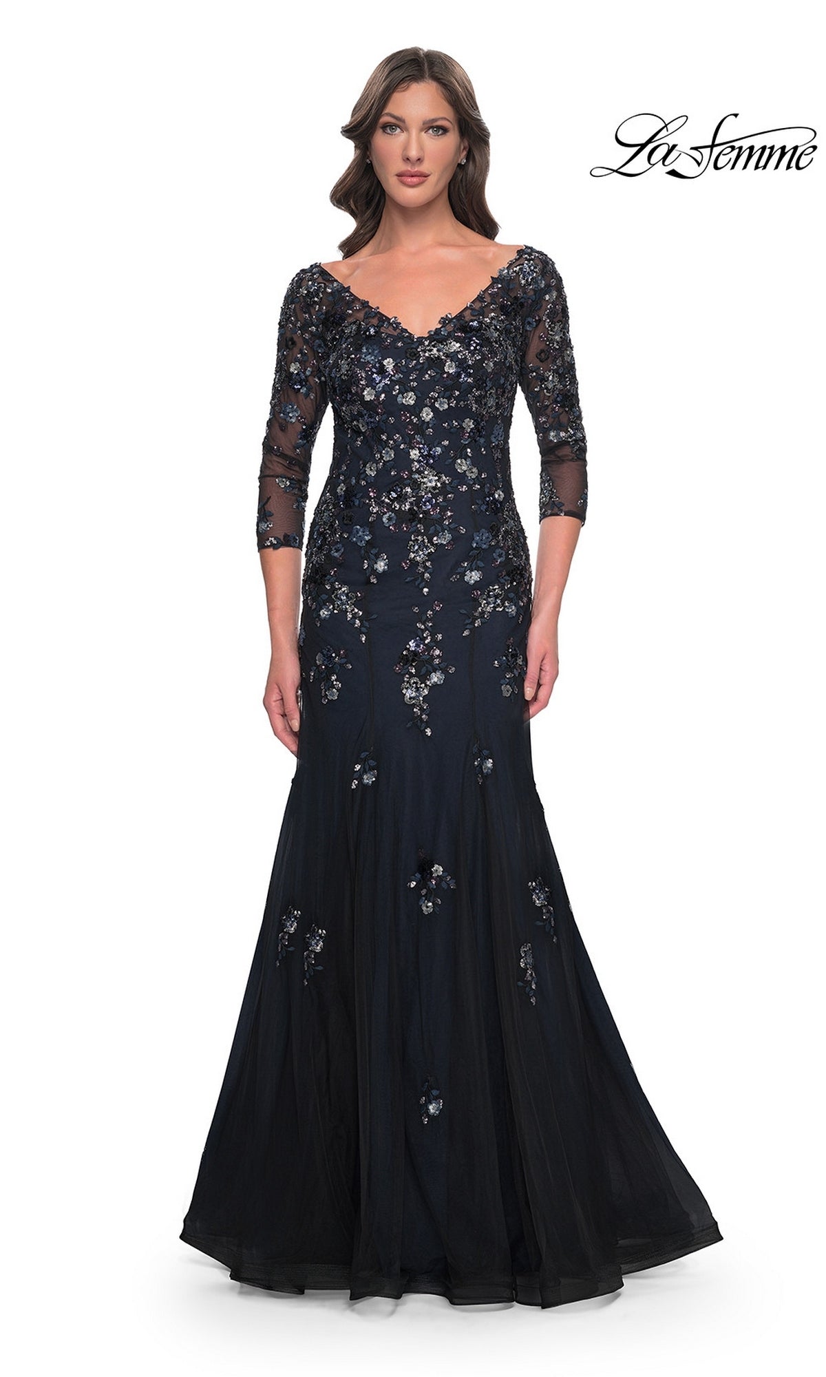 A woman wears a La Femme 30860 long formal dress, a floor-length, off-the-shoulder navy mermaid gown with three-quarter sleeves and floral sequin embellishments.