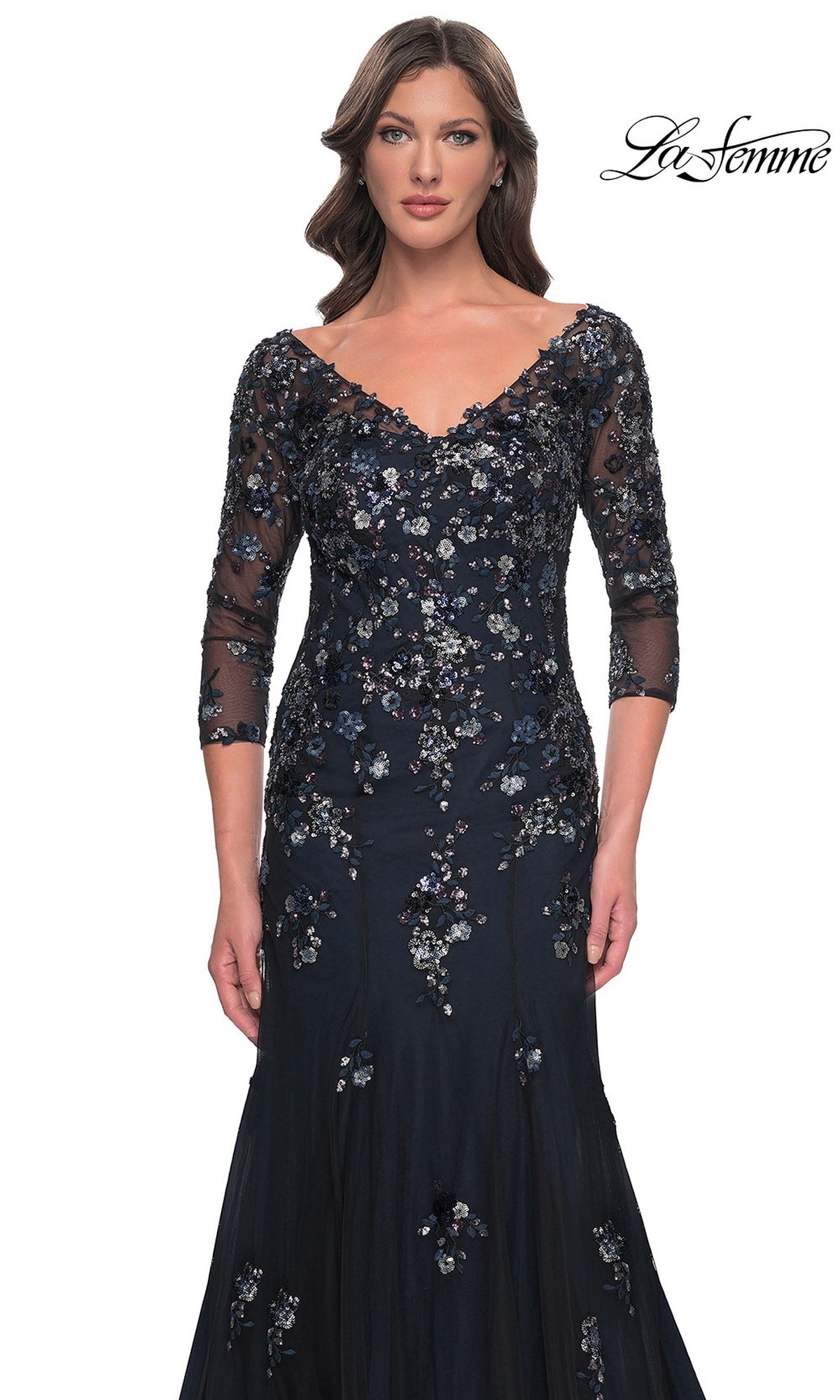 A woman wearing a La Femme 30860 long formal dress, a dark navy, V-neck, three-quarter sleeve mermaid gown covered in floral embroidery and sequins.